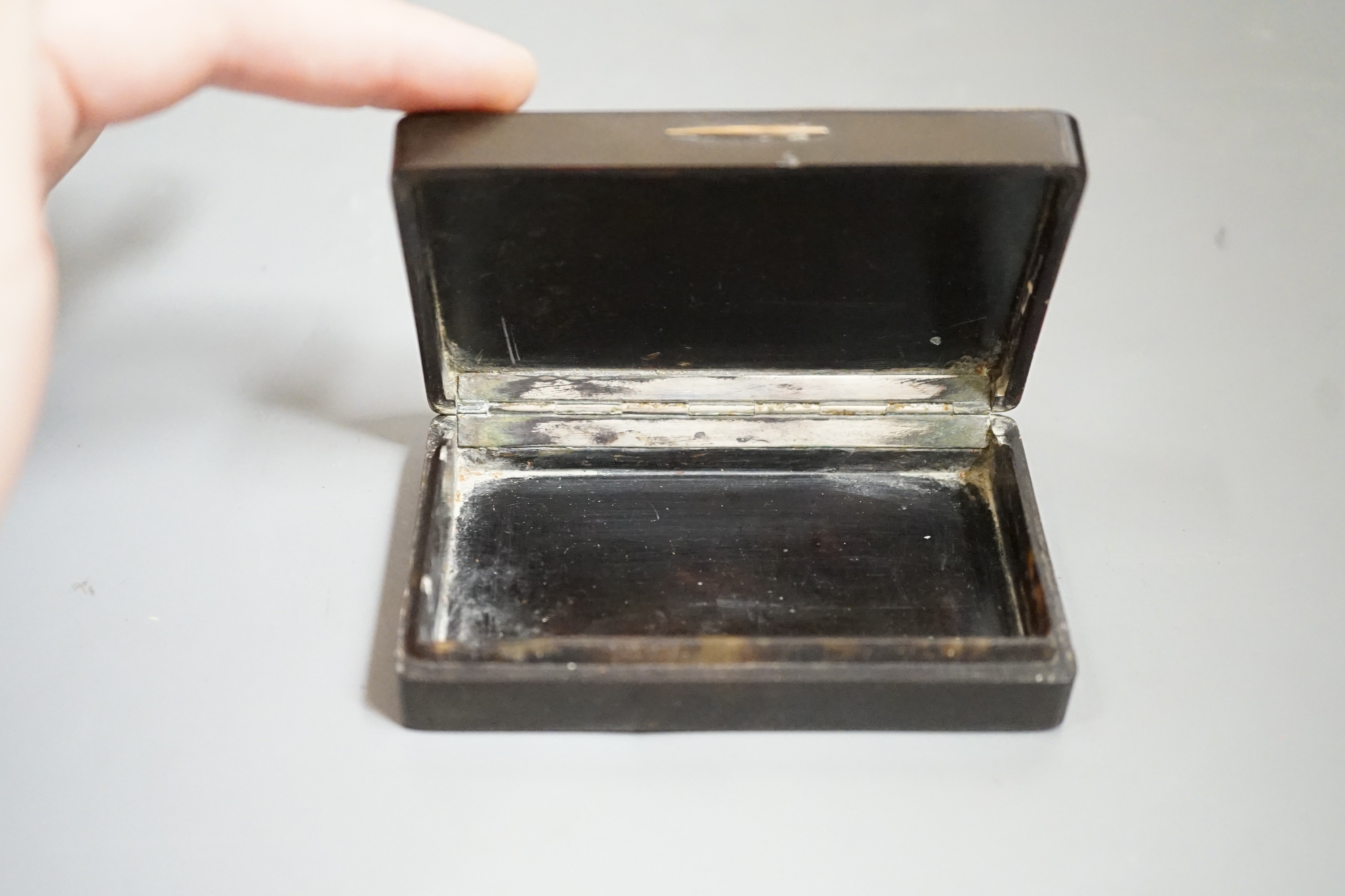 A 19th century French tortoiseshell snuff box, the top with reverse painted glass scene Tuileries Palace, Paris, J F Lebell, 9cms wide x 5.5cms